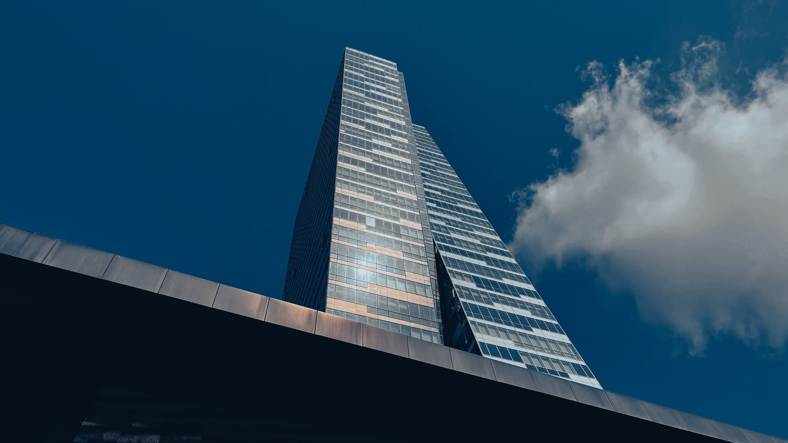 Glass office tower in Istanbul seen from below against a deep blue sky