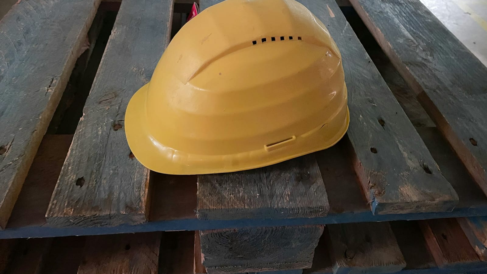 Ahşap palet üzerinde sarı baret