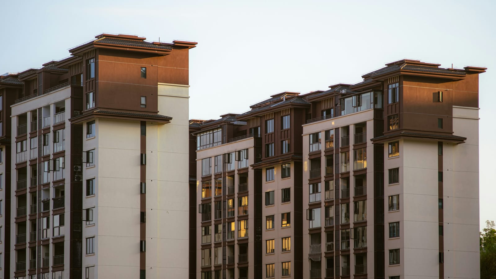 Akşam ışığında, kahverengi ve krem cepheli, yeni tamamlanmış iki çok katlı apartman bloğu