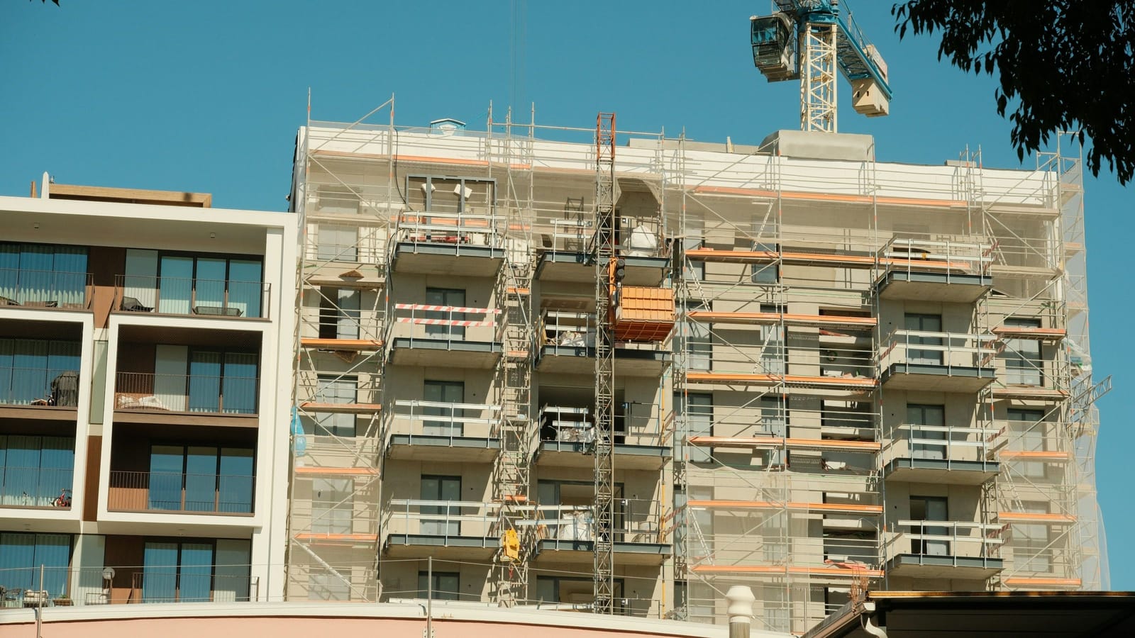 İskeleyle çevrili, yapımı süren çok katlı bir apartman ve arkasında kule vinç