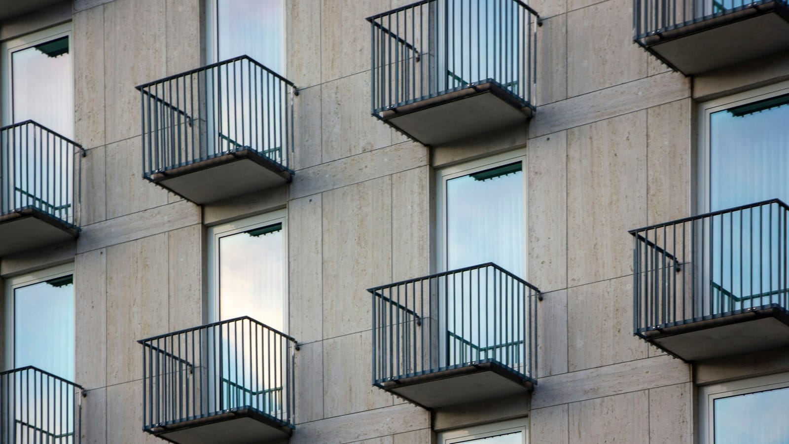 Aynı biçimde tasarlanmış balkonların sıra sıra dizildiği bir apartman cephesi