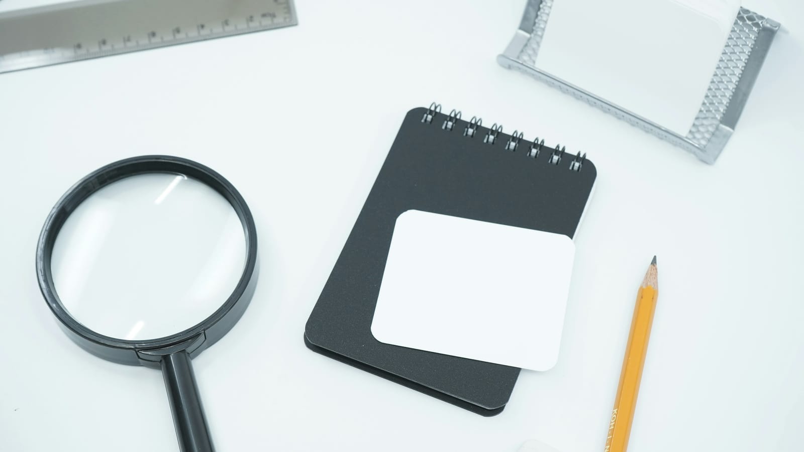 Defter, büyüteç ve kalem